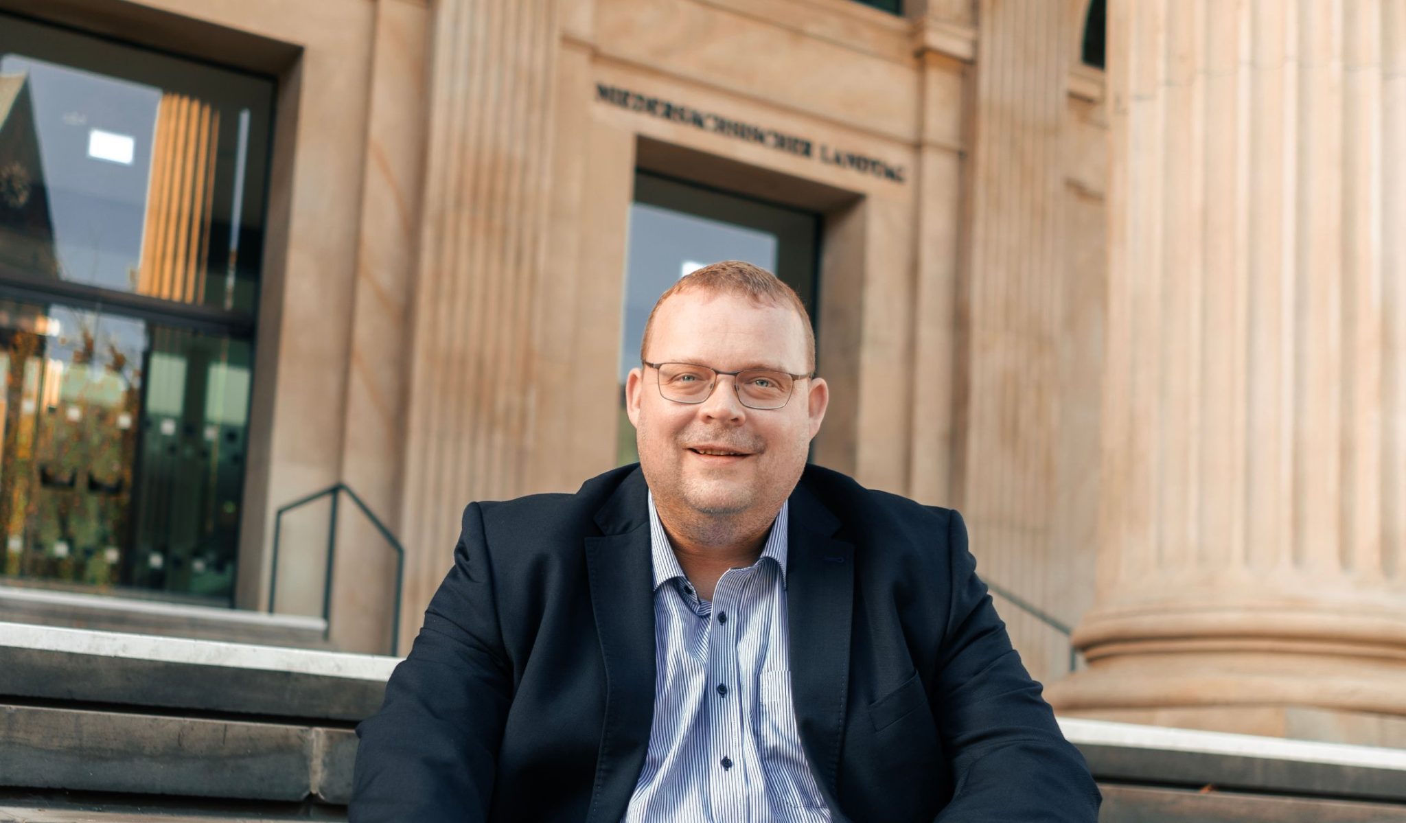 Ansgar Schledde sitzt vor dem niedersächsischen Landtag