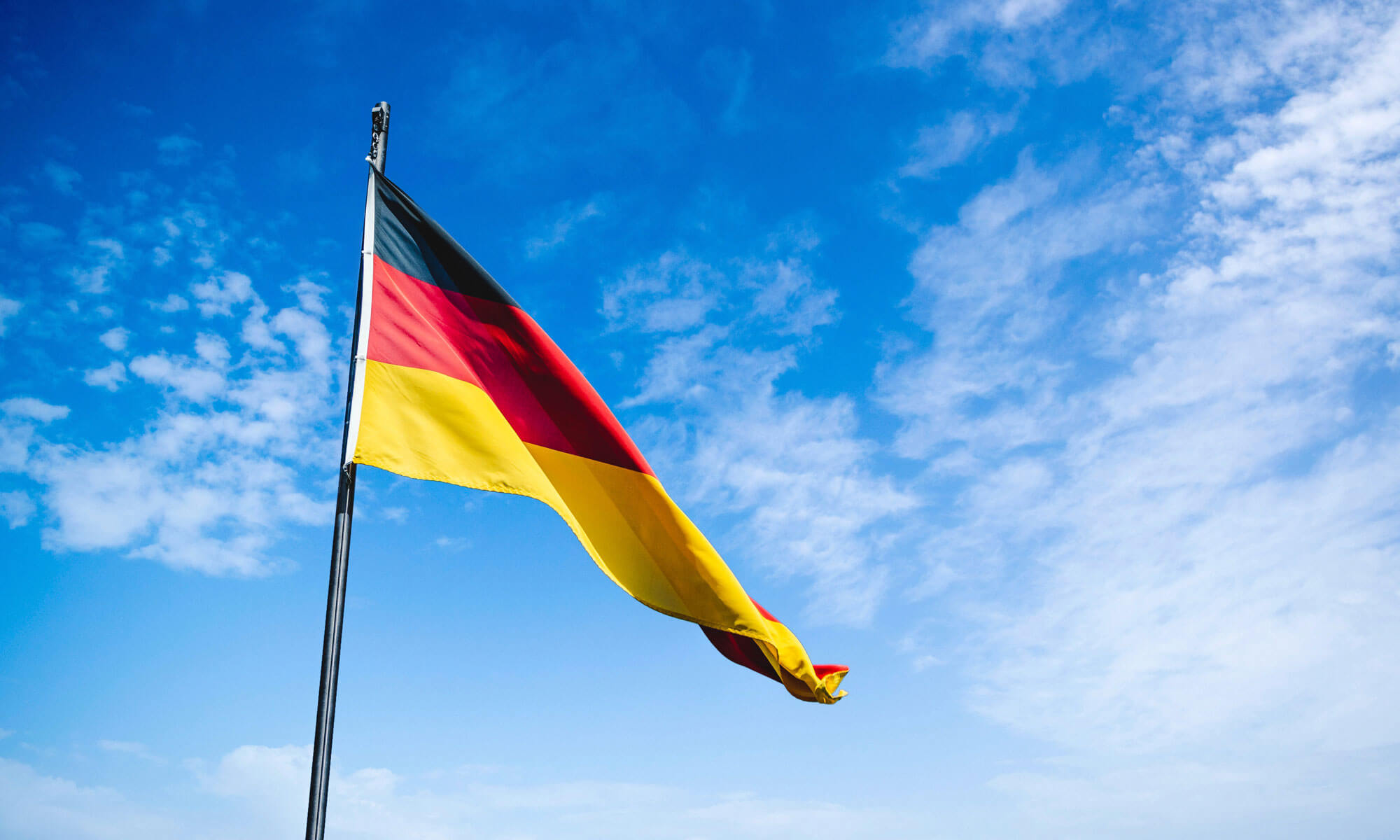Flagge der Bundesrepublik Deutschland vor blauem Himmel